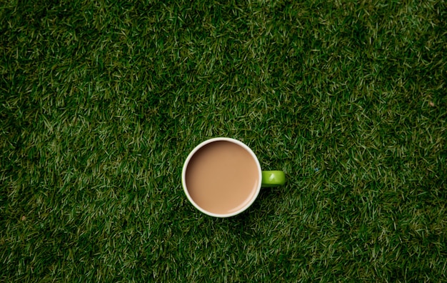 Vue de dessus sur une tasse de café sur l'herbe verte.