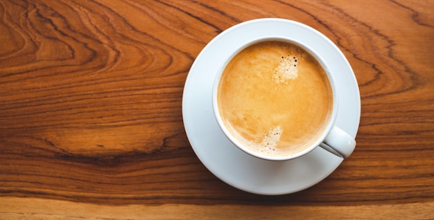 Vue de dessus de la tasse à café avec de la mousse sur une table en bois