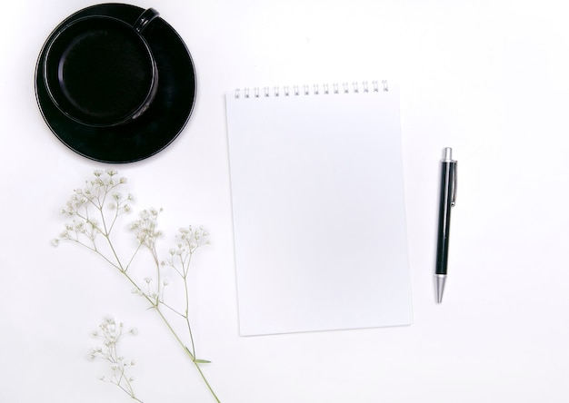 vue de dessus d'une tasse de café et d'un ordinateur portable avec des fleurs sur fond blanc