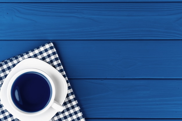 Photo vue de dessus d'une tasse de café sur soucoupe sur fond bleu classique