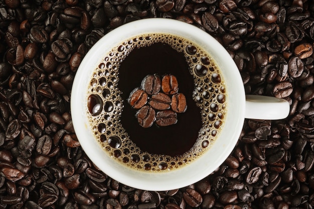 Vue de dessus de la tasse avec du café sur fond de café torréfié