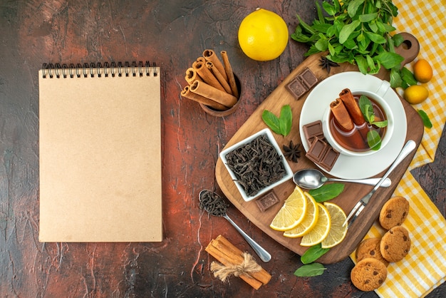 vue de dessus tasse de thé avec des tranches de chocolat et de citron sur fond sombre cacao fruits cérémonie du petit-déjeuner couleur biscuit au thé sucré