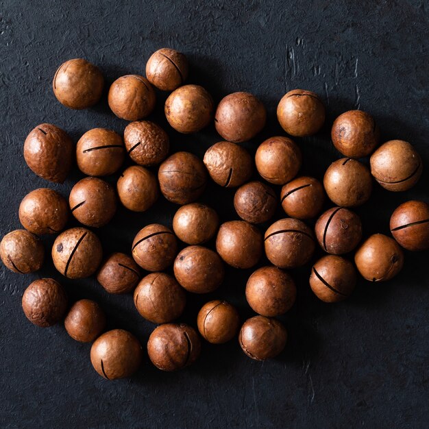 Photo vue de dessus de la texture des noix de macadamia crues naturelles sans coque et fraîches