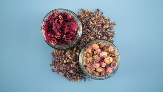 Vue de dessus de tisane avec et fleurs sèches sur fond bleu