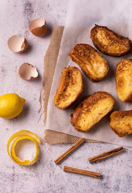 Vue de dessus des Torrijas de Pâques espagnols traditionnels fraîchement cuits au four et des ingrédients sur la table