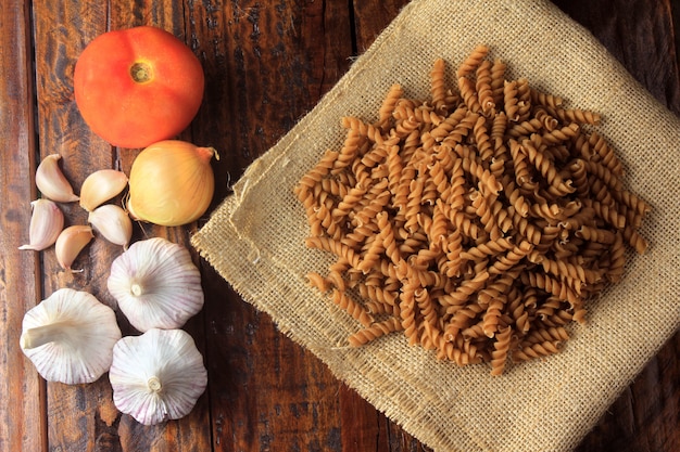 Vue de dessus de toute la masse de Fusilli, sur un tissu, une serviette rugueuse, sur un fond en bois.