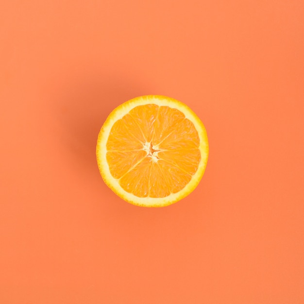 Vue de dessus d&#39;une tranche de fruit orange sur fond clair en couleur orange.