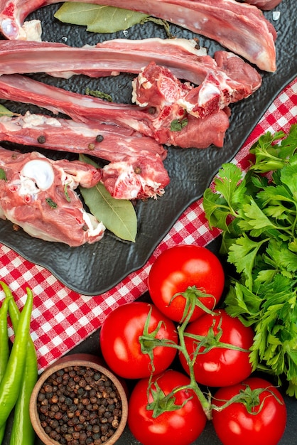 Vue de dessus des tranches de viande crue avec des légumes verts et des légumes frais sur un fond sombre plat de viande dîner nourriture cuisine boucher repas salade