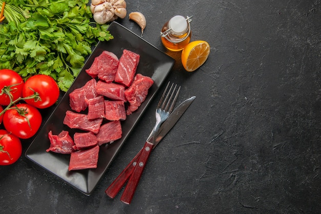 vue de dessus des tranches de viande fraîche avec des verts et des tomates