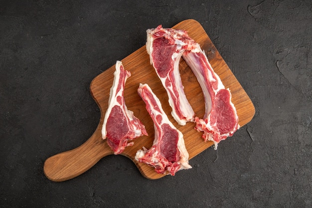 Vue de dessus des tranches de viande fraîche de viande crue sur une surface sombre viande de boucherie repas alimentaire couleur animale barbecue