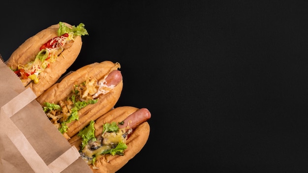 Vue de dessus de trois hot-dogs dans un sac en papier avec espace copie