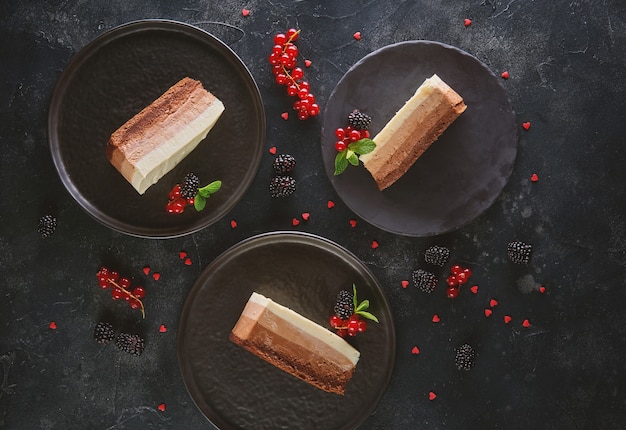 Vue de dessus de trois tranches de gâteau mousse sur fond sombre