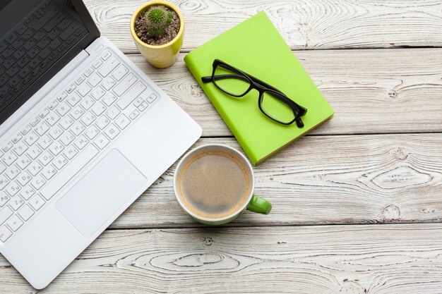 Vue de dessus des trucs de bureau avec ordinateur portable et café