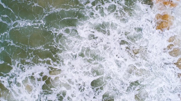 Vue de dessus des vagues de texture de la mer moussant et éclaboussant dans l'océan Journée ensoleillée beau fond de surface de la mer