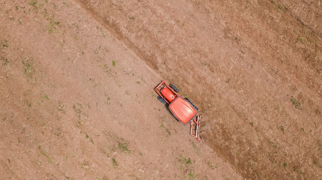 Vue de dessus des véhicules de tracteur agricole travaillant au champ