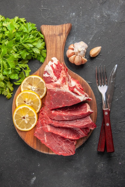 vue de dessus de la viande fraîche en tranches avec des légumes verts et des tranches de citron. nourriture dîner repas cuisson viande