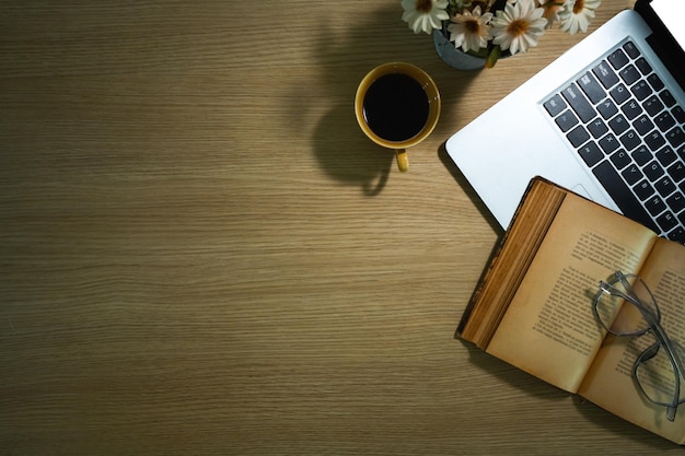 Vue de dessus d'un vieux livre de tasse à café pour ordinateur portable et de lunettes sur une table en bois rustique Copiez l'espace pour le texte