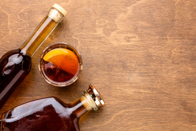 Photo vue de dessus whisky et orange avec des bouteilles et copie-espace
