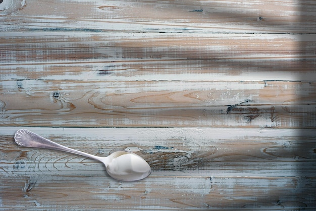 Vue de dessus yaourt dans une cuillère blanche sur une table en bois a ajouté un espace de copie pour le texte