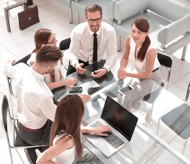 Vue de dessuséquipe commerciale assise au bureau