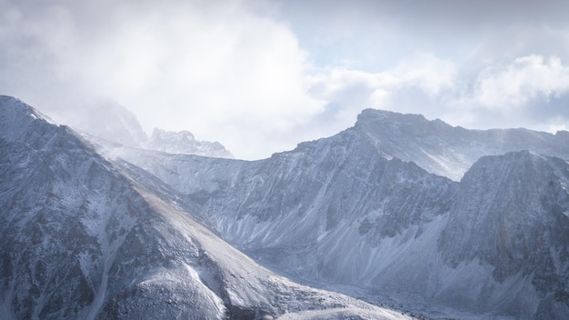 Vue détaillée sur la crête de la montagne entourée de nuages et couverte de neige pendant la saison hivernale Canada