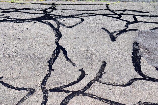 Vue détaillée des surfaces d'asphalte de différentes rues et routes avec des fissures