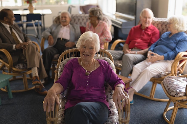 Vue de devant d'une femme âgée regardant la caméra dans une maison de retraite