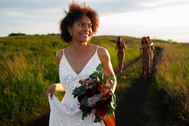 Photo vue de devant de la mariée et des demoiselles d'honneur dans la nature