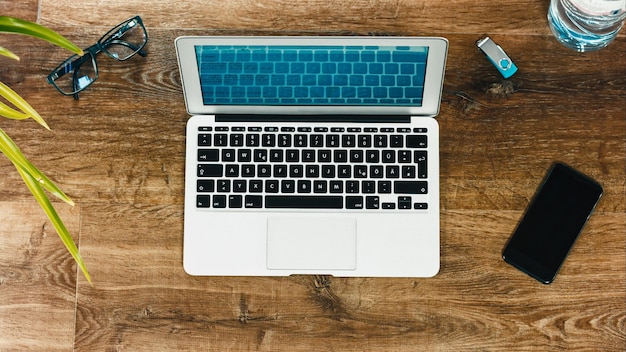 Vue directement au-dessus de l'ordinateur portable avec le téléphone portable sur la table