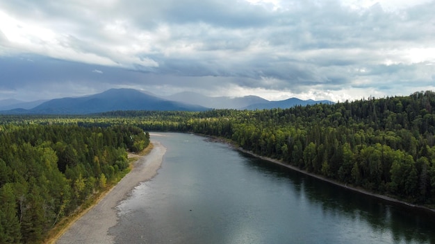 Vue de drone de paysage de nature sauvage avec rivière et forêt. Débit de la rivière sibérienne de montagne, eau sur pierre