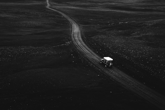 Vue d'un drone Suzuki Jimny roulant sur un chemin de terre