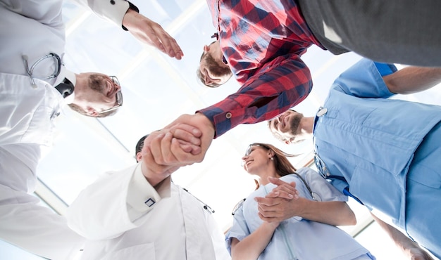 Vue du bas d'une grande équipe médicale debout en cercle souriant