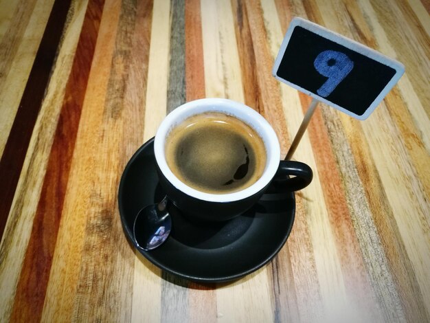 Photo vue du café noir sur une table en bois par le numéro 9