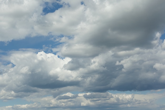 Vue du ciel bleu avec d'épais nuages blancs. Couverture nuageuse dense de cumulus. Journée d'été, nature. Flou artistique. Bruit artificiel. Contexte.