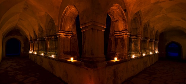 Photo vue du cloître de l'abbaye la nuit éclairée par des bougies dans le parc national de killarney co kerry en irlande