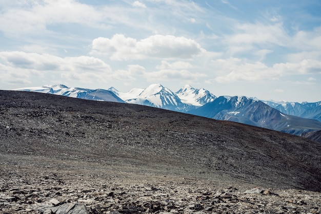 Vue du col pierreux à la chaîne de montagnes enneigées.