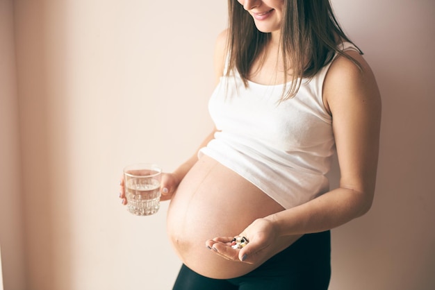 Vue du côté d'une femme enceinte prenant des vitamines