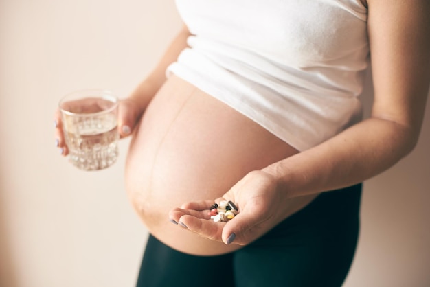 Vue du côté d'une femme enceinte prenant des vitamines