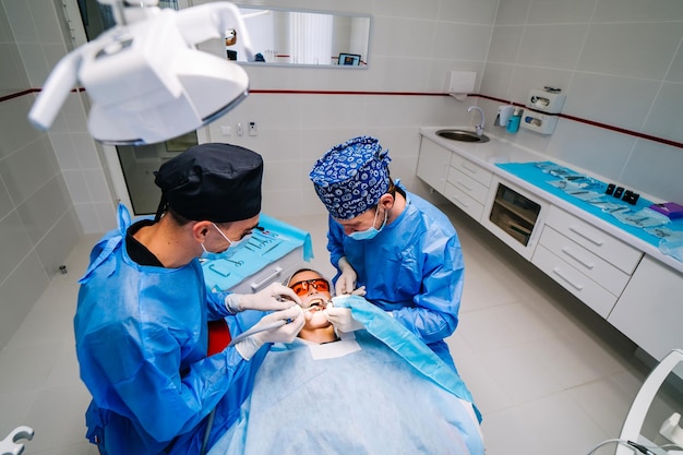 Vue Du Haut Sur L'opération Dentaire Chirurgicale Patient Sur Lit Dentaire Deux Dentistes Avec Patient Stomatologie