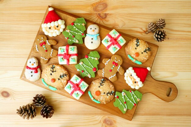 Vue du haut d'un plateau en bois rempli de délicieux biscuits de Noël décorés de cônes de pin secs