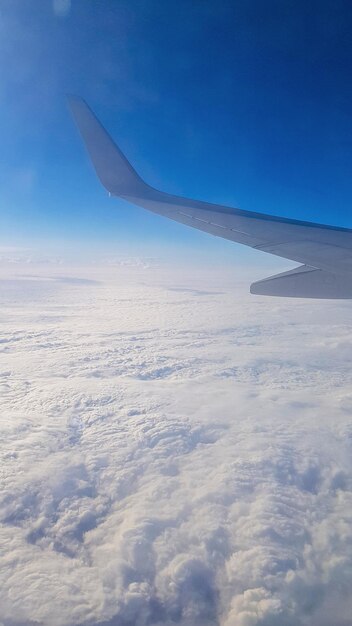 Vue du hublot de l'avion sur le beau ciel bleu et les nuages d'air