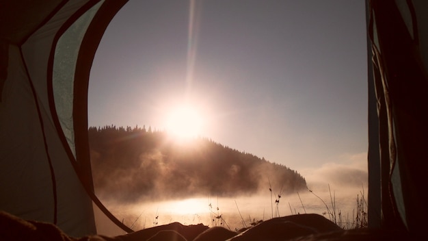 Vue du lever du soleil de la tente à la montagne Concept de sport et de vie active