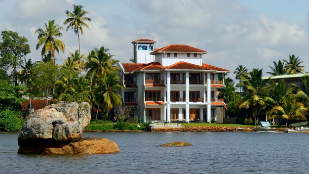 La vue du manoir sur le rivage avec des palmiers action vivant au rivage de la mer avec le vert