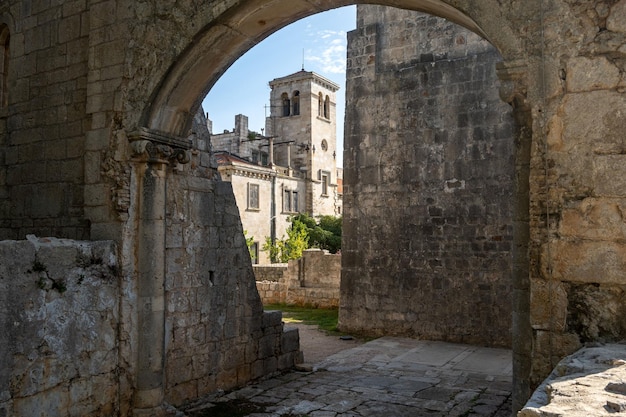 Photo vue du monastère bénédictin de sainte-marie à travers une vieille porte en pierre sur l'île de lokrum en croatie