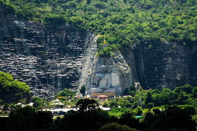 Vue du paysage et de la sculpture de grand bouddha sculpté sur la montagne de la falaise de pierre Wat Khao Tham Thiam pour les voyageurs thaïlandais visitent le respect priant la bénédiction à U Thong à Suphan Buri en Thaïlande