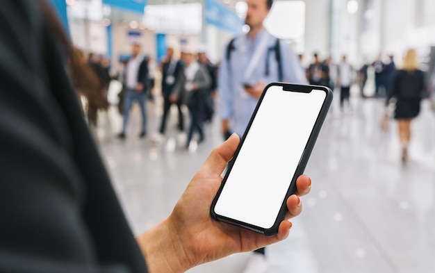 vue du téléphone dans des mains féminines avec écran vide, avec une foule de personnes, espace de copie pour votre texte individuel.