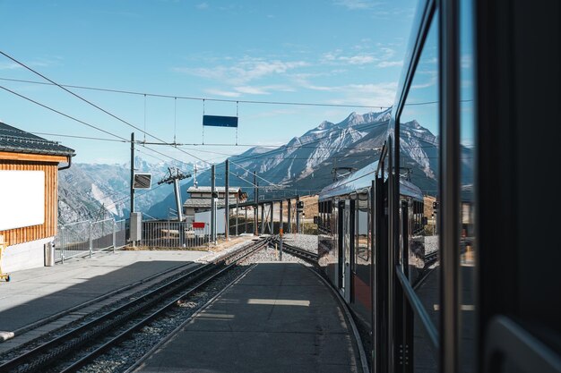 Photo vue du train en cours d'exécution à la station parmi les alpes suisses en suisse