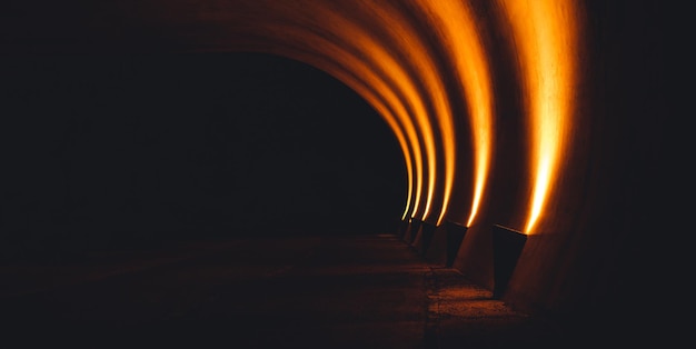 Vue du tunnel sombre avec des lumières orange.