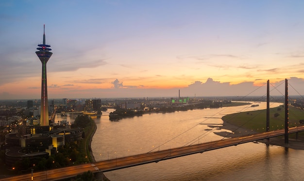 Vue sur Dusseldorfat au coucher du soleil avec la tour du Rhin (Rheinturm) et le pont Knie du Rhin. idéal pour les mises en page de sites Web et de magazines