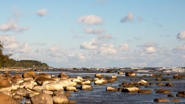 Une vue sur l'eau avec un phare sur les rochers